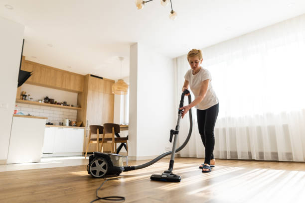 active senior woman tidying up the living space at home