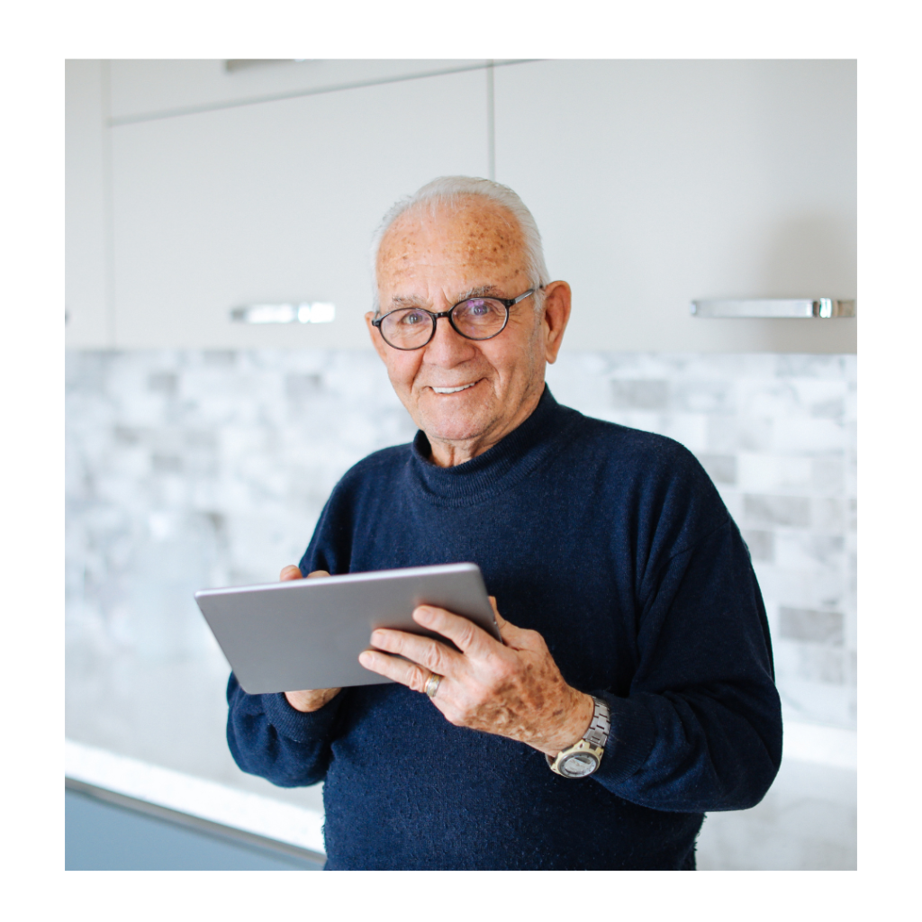 A senior relaxing at home while working on a tablet.