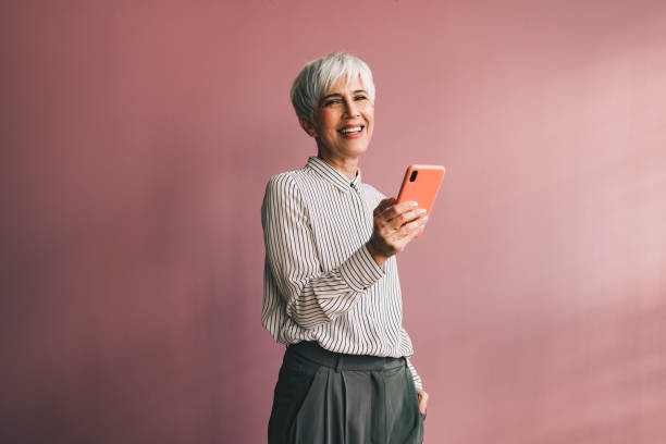 A successful senior woman as a social media influencer on her phone.